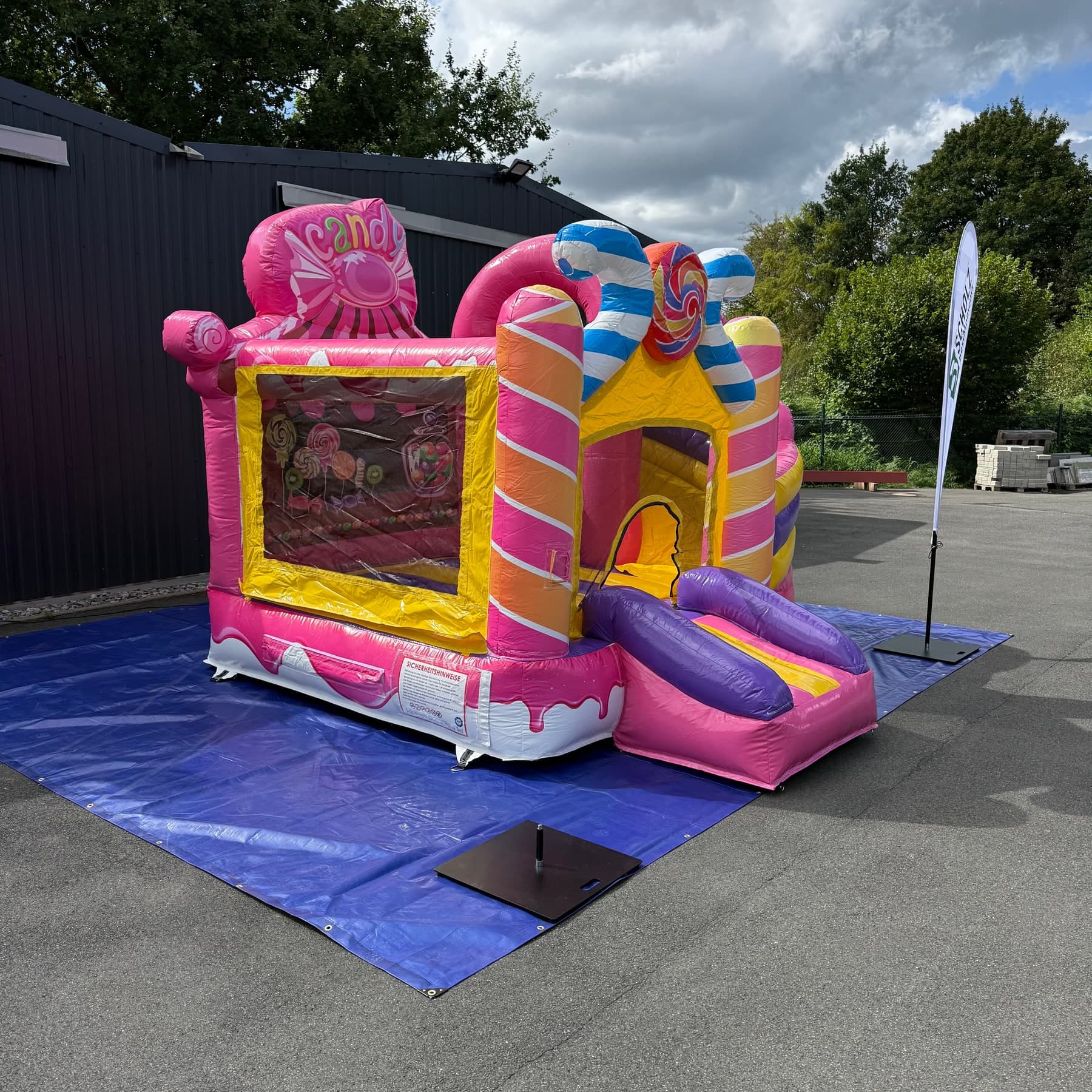 Hüpfburg Candyland mit Bonbon-Dekoration und Sicherheitsnetz von der Seite