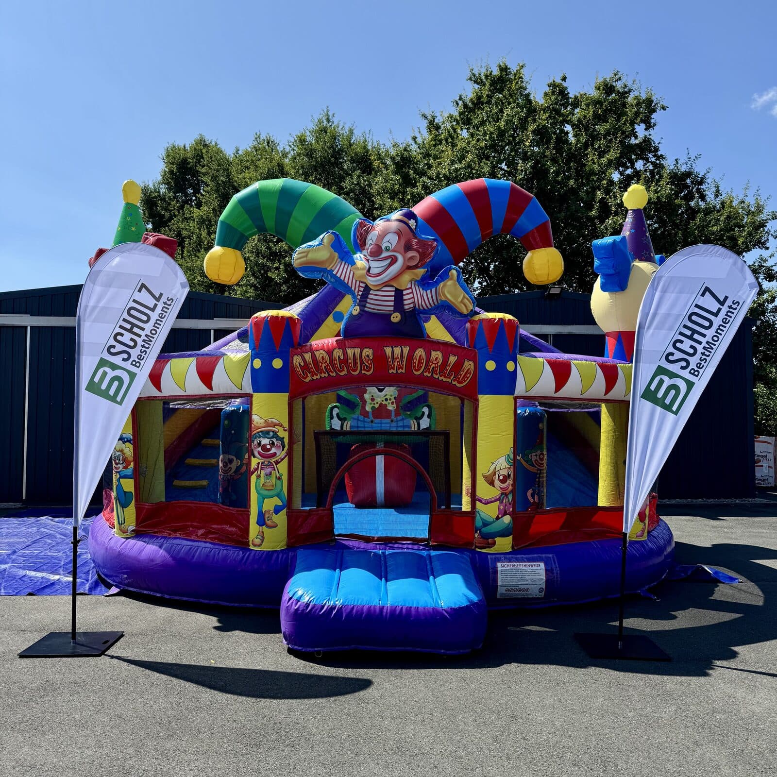 Hüpfburg Multiplay Zirkus mit Rutsche von vorne, daneben die Beachflags von Scholz BestMoments
