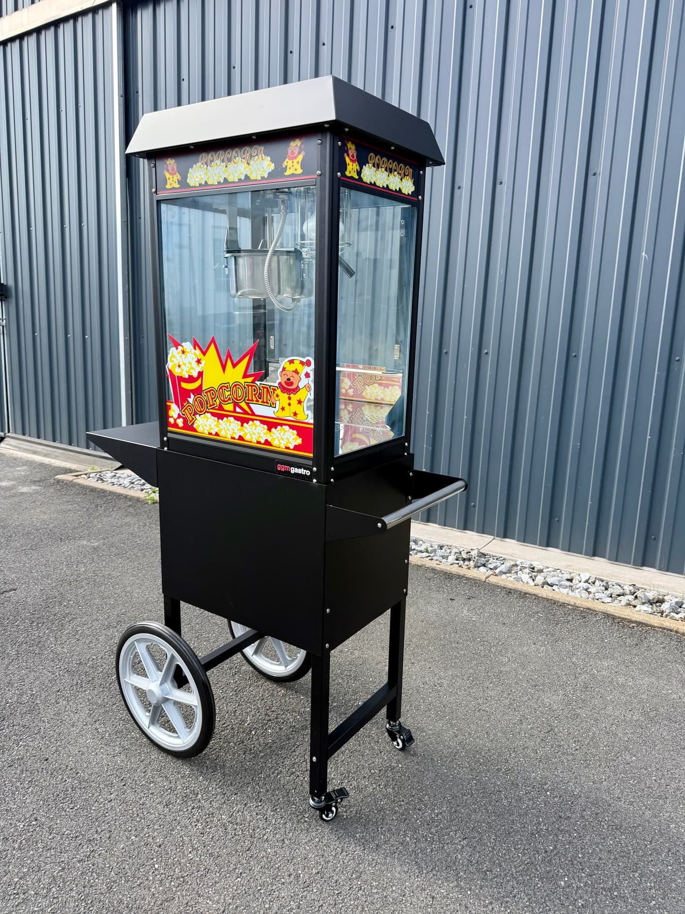 Nostalgische Popcornmaschine auf schwarzem Wagen mit weißen Rädern