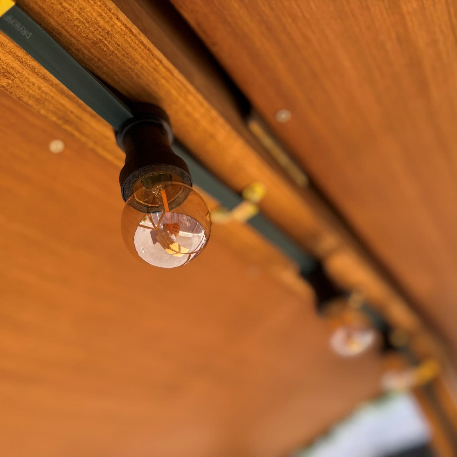 Detailaufnahme einer Glühbirne der Innenbeleuchtung unter dem Holzdach
